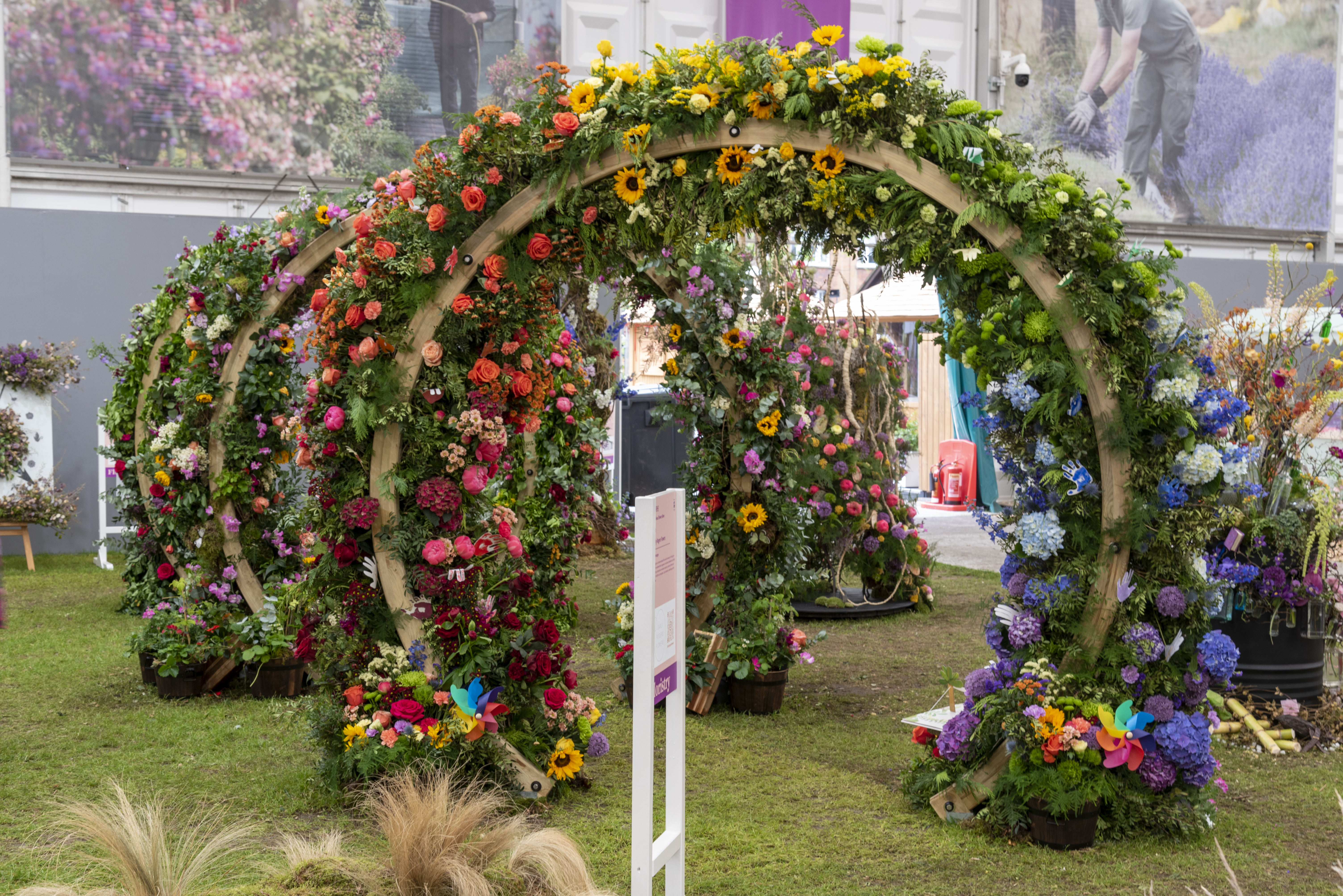 Carly Rogers - arches of flowers and leaves on grass at the Chelsea Flower Show