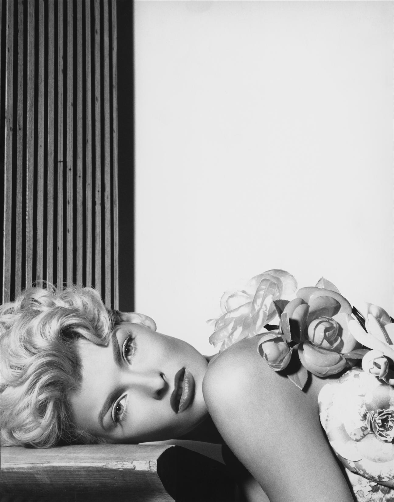 Steven Meisel - A woman laying her head on a table