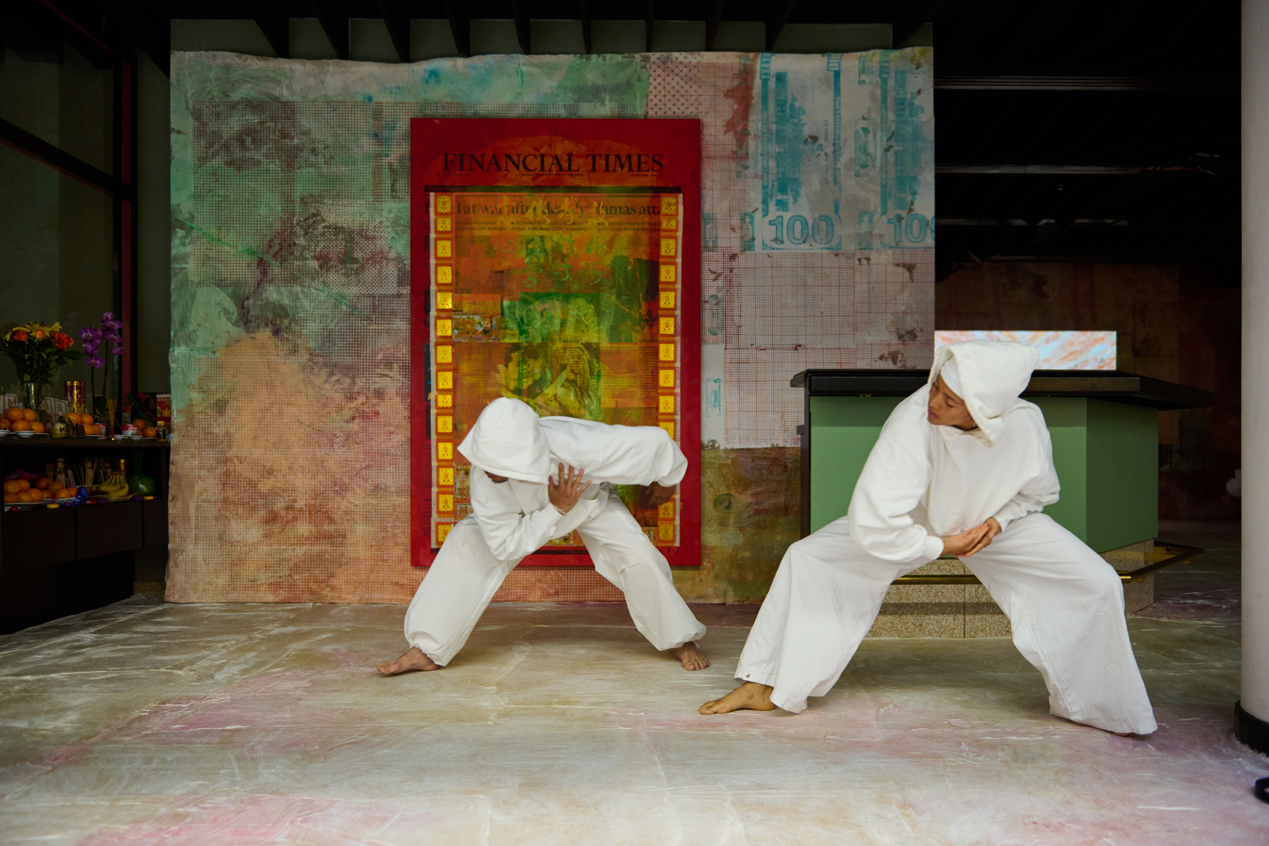 Mandy El-Sayegh - Two people in karate uniforms performing in front of a colourful wall