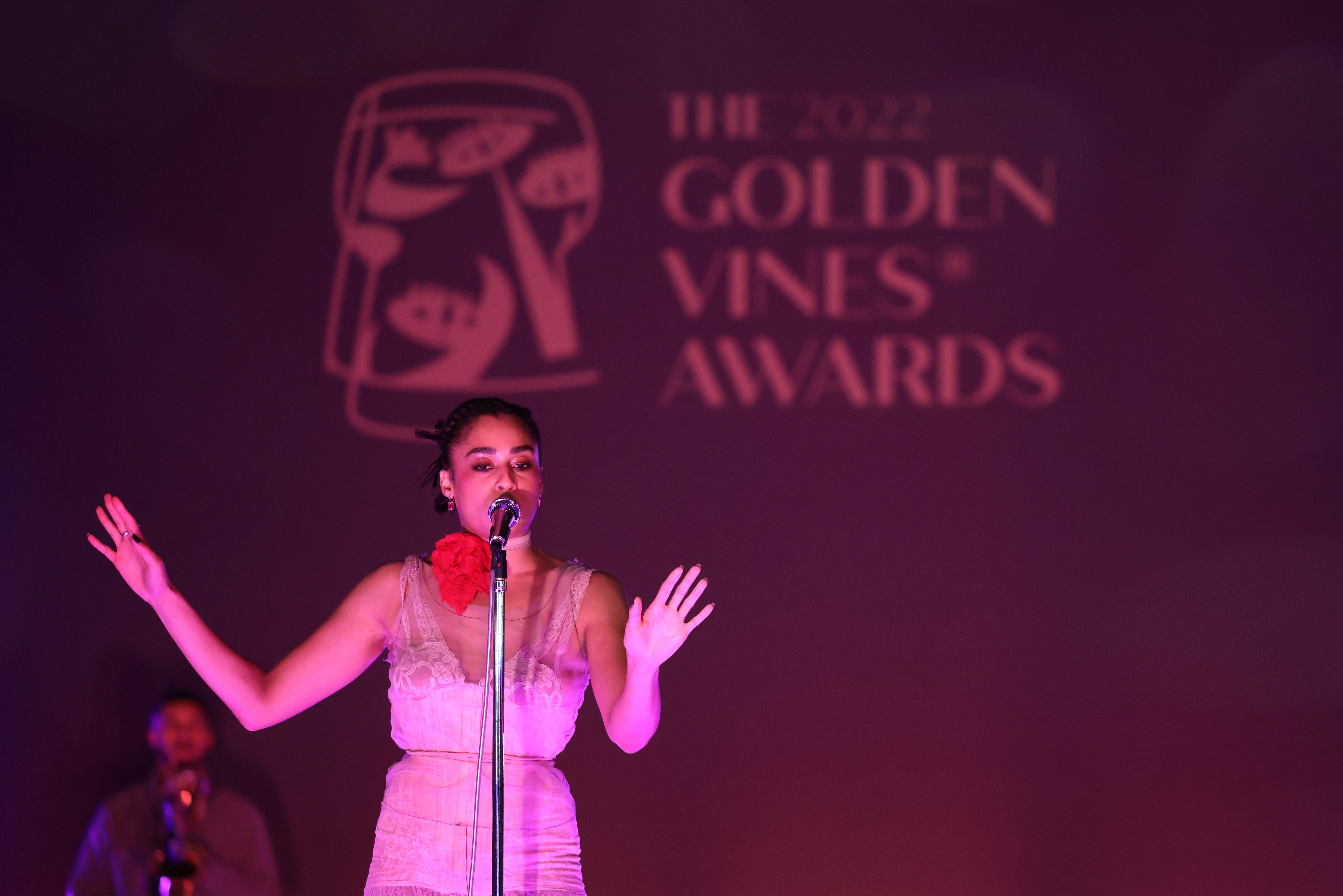 Golden Vines 2022 - a woman singing in a pink light