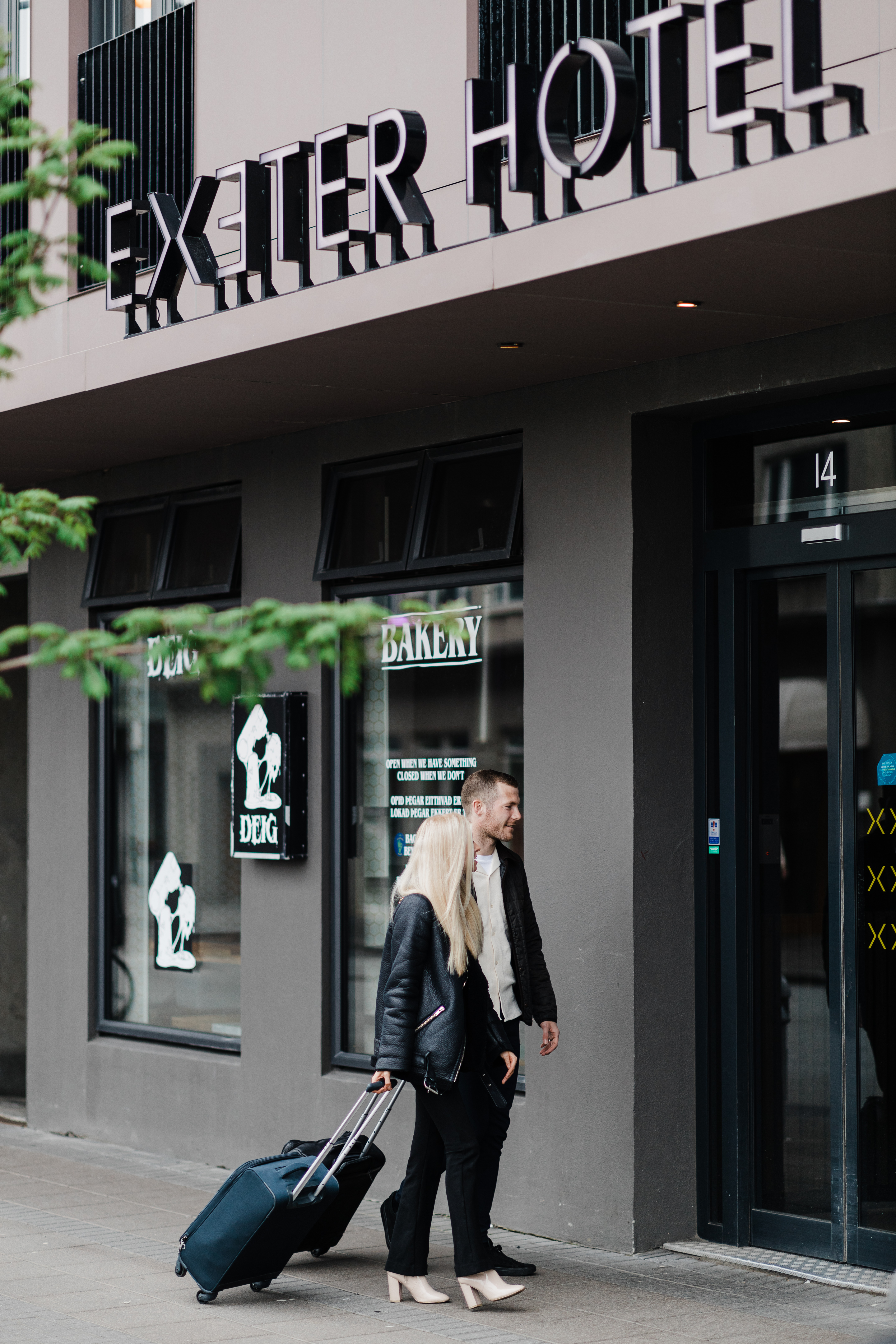 Exeter Hotel - entrance to a hotel with people standing outside with a suitcase