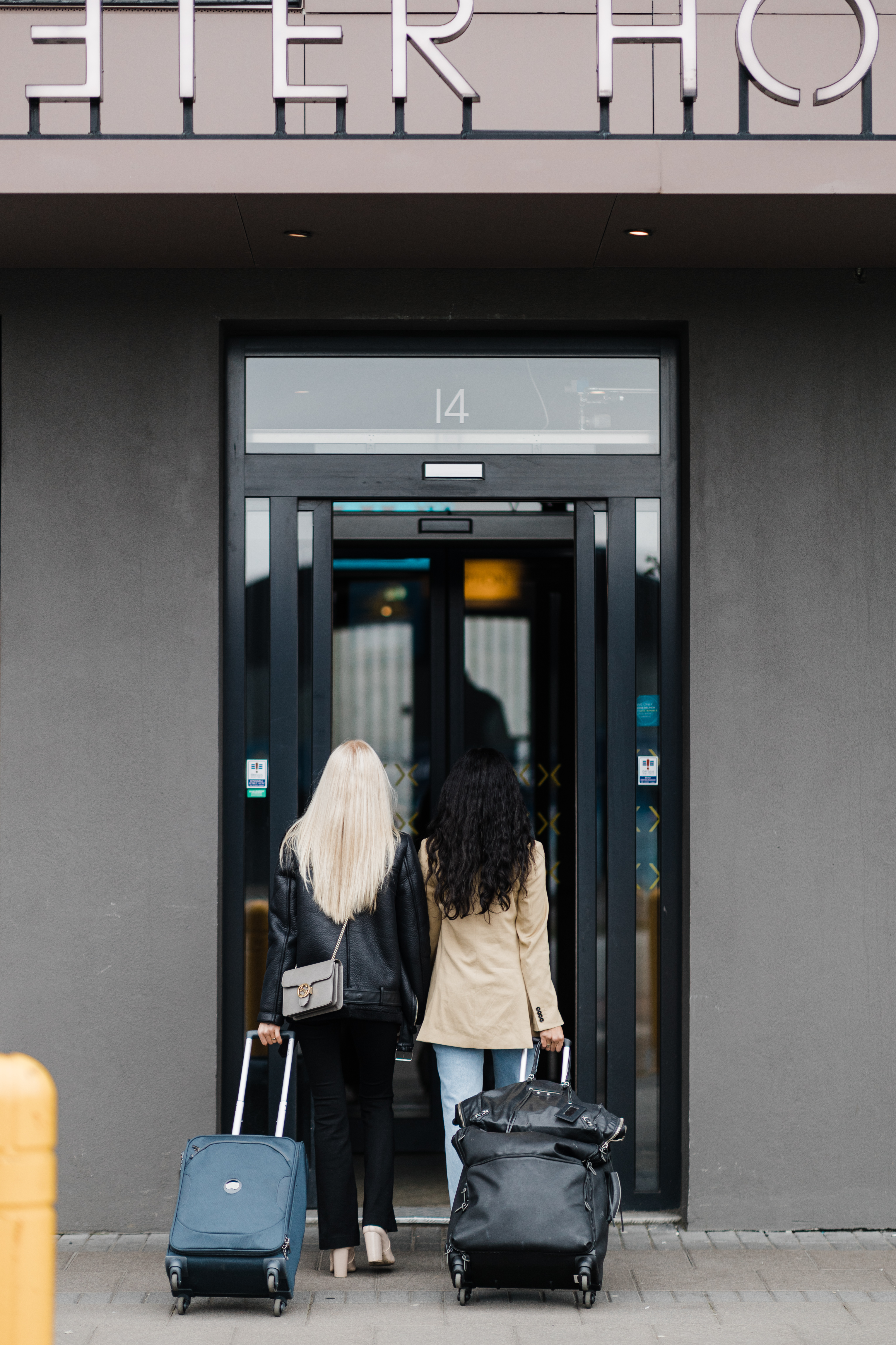 Exeter Hotel - two people walking through the entrance with luggage