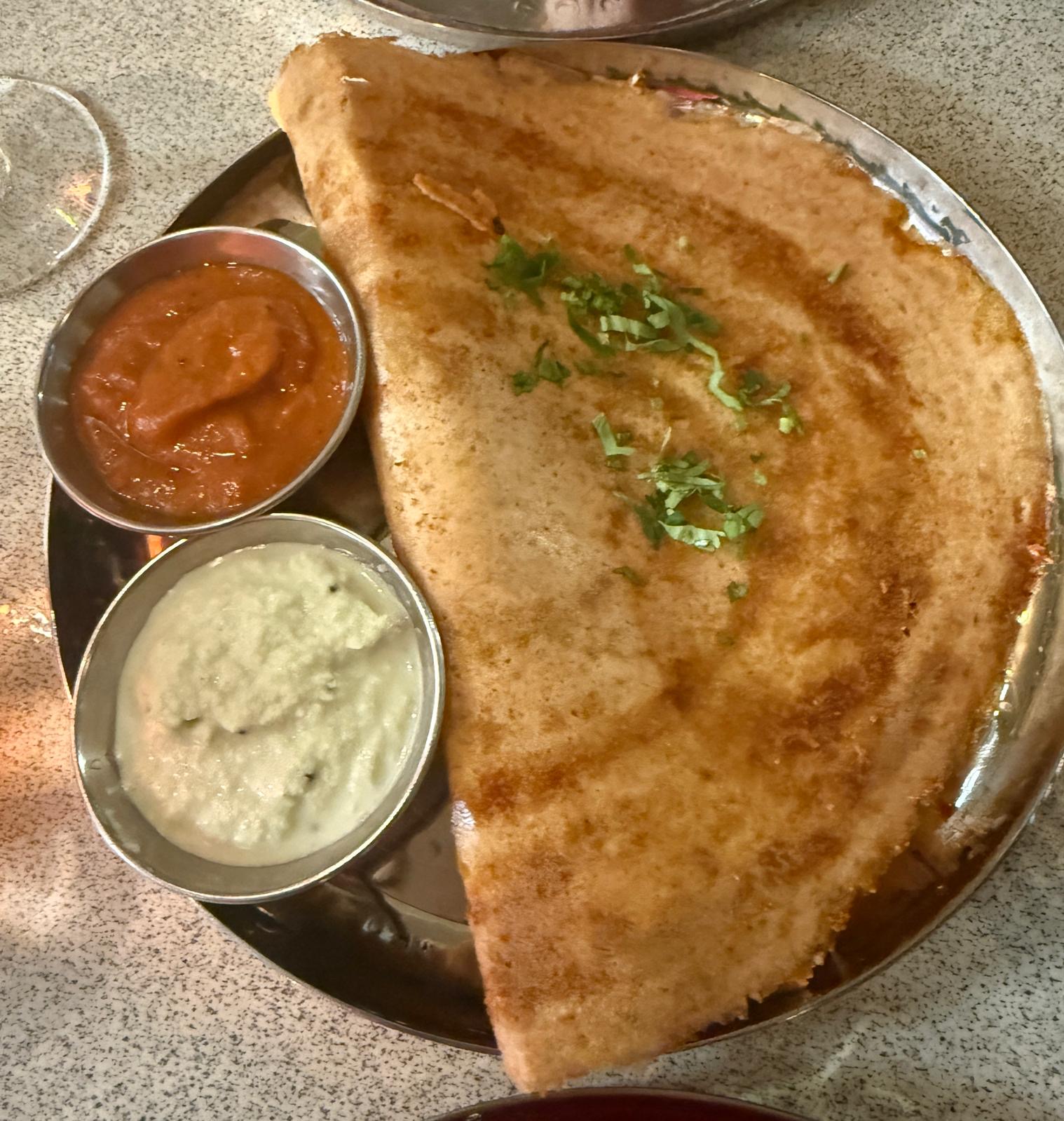 Tamila Restaurant Kings Cross - masala dosa topped with herb garnish alongside two silver bowls of orange and white sauce