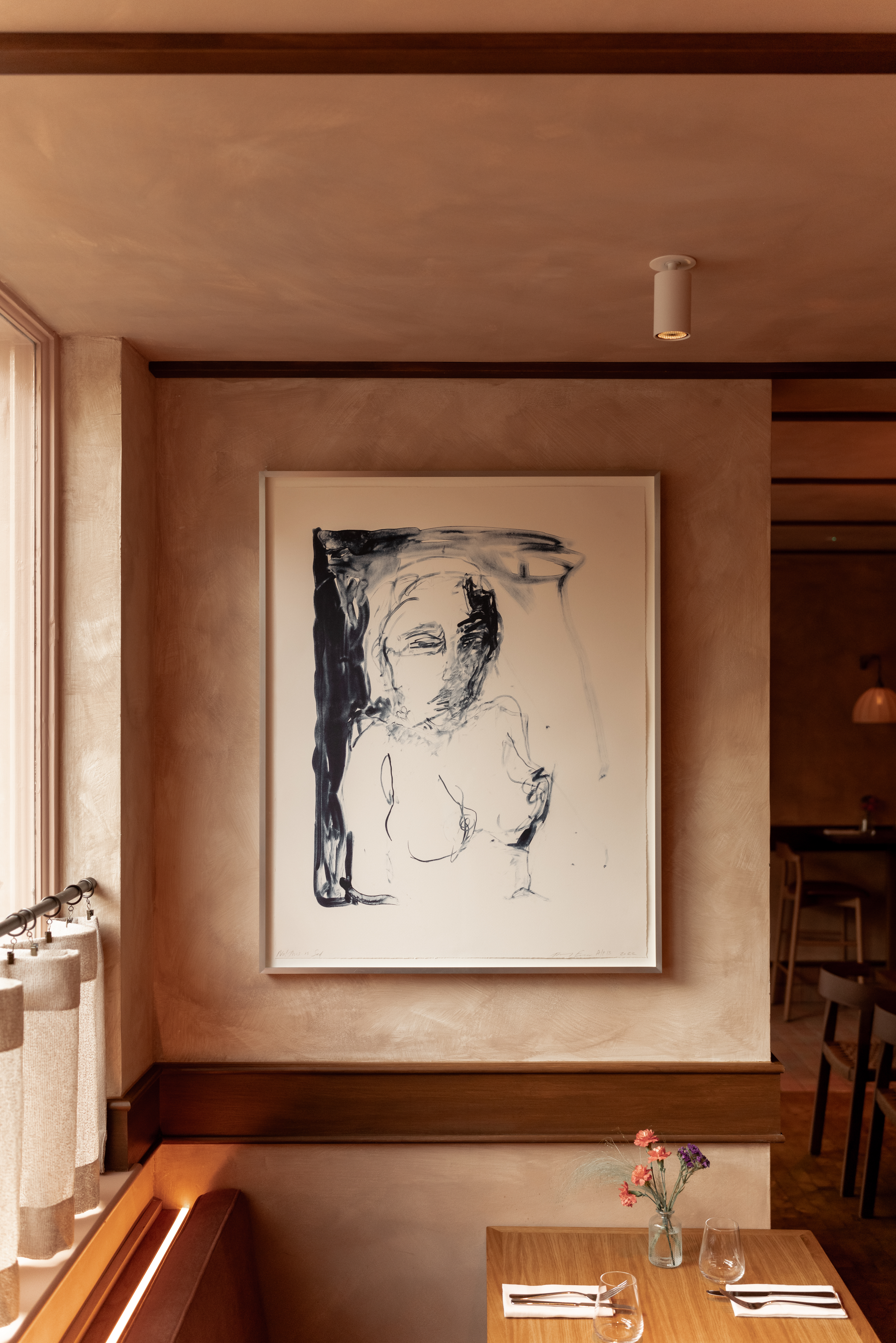 Art restaurants in London - The interior of Lolo on Bermondsey street with This is Sad by Tracey Emin featured on the wall above a laid table.