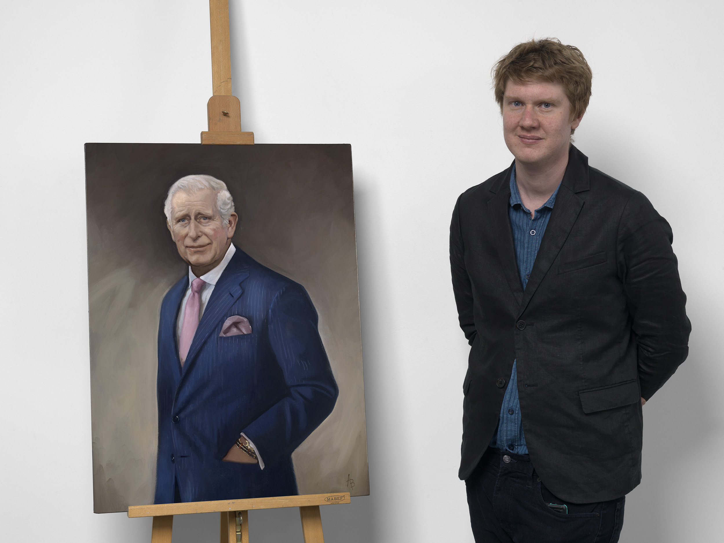 Terrence Higgins Trust Auction 2025 - Alastair Barford stood alongside his portrait of King Charles III