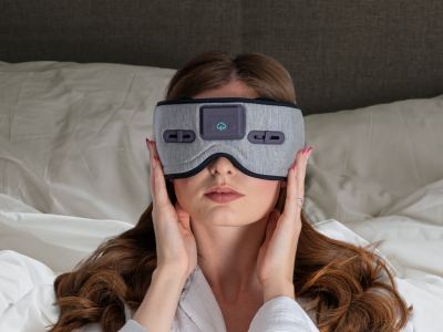 Effective Products Deeper Sleep - a woman lying down on white pillows with a grey sleep mask on